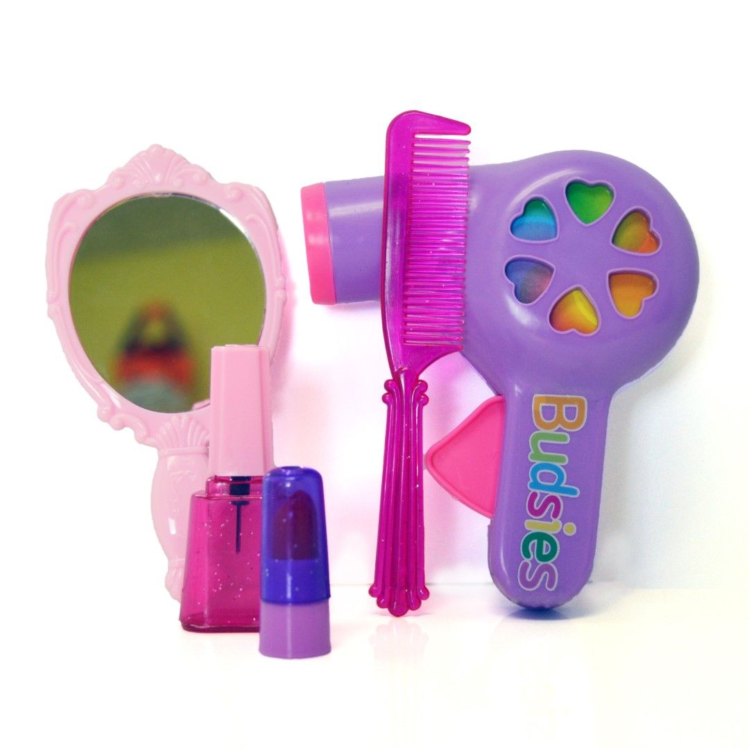 Select to view 'Set of colorful kids' beauty toys including a purple toy hairdryer with heart designs, pink plastic comb, handheld pink mirror, and toy nail polish.' image